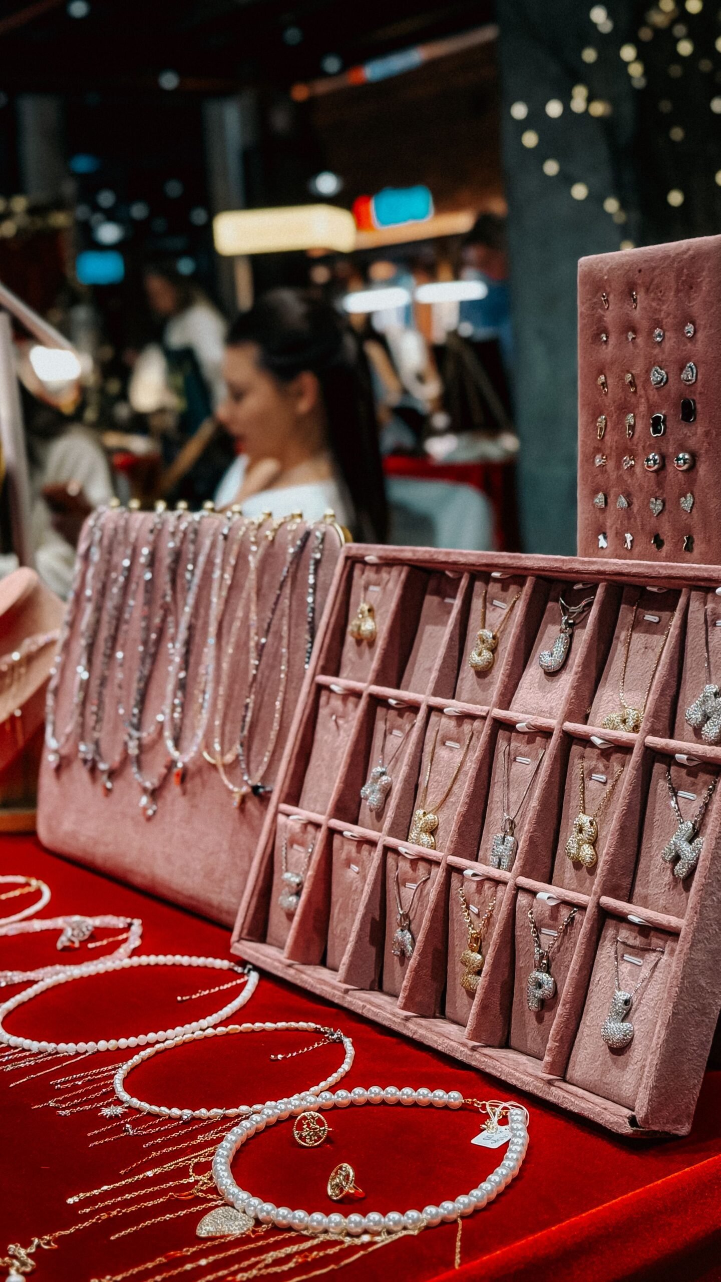A vibrant indoor market showcasing elegant necklaces and earrings on a velvet display.